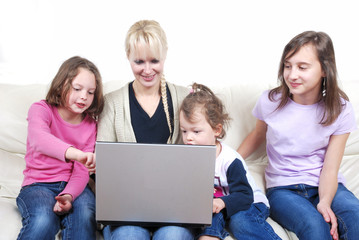 Family sitting on the sofa and using laptop