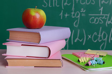 School supplies on table on board background