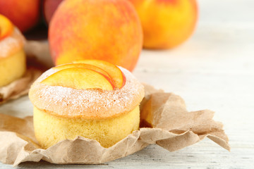 Tasty mini cake with fresh peach, on wooden table
