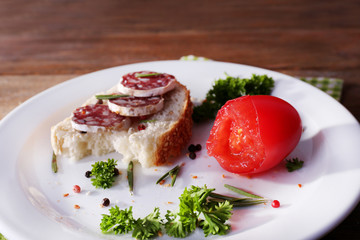 Sandwich with salami on napkin on wooden background