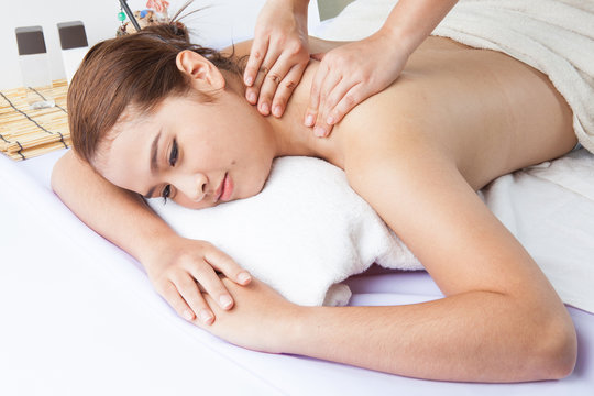 Close-up of a young woman receiving back massage at spa