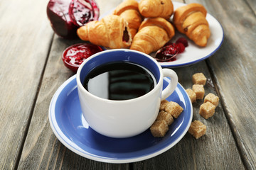 Breakfast with tea, raspberry jam and fresh croissants