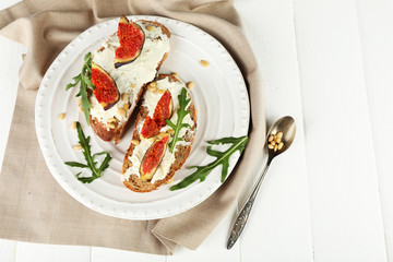 Tasty sandwiches with sweet figs and cottage cheese on plate