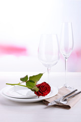 Table setting with red rose on plate