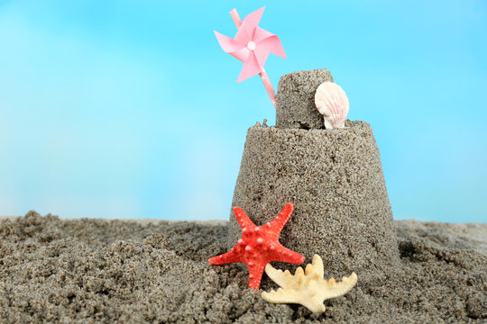 Sandcastle With Pinwheel On Sandy Beach