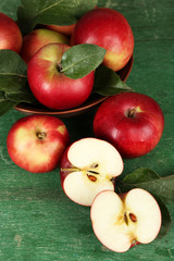 Ripe apples in bowl on wooden background