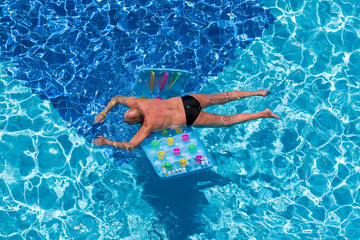 man relaxing on swimming-pool