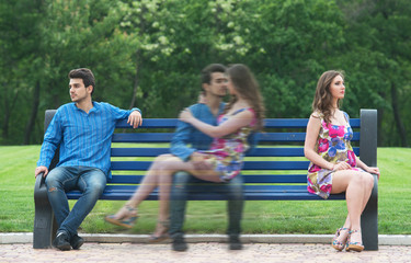 Couple sitting apart on bench and remembering their love story