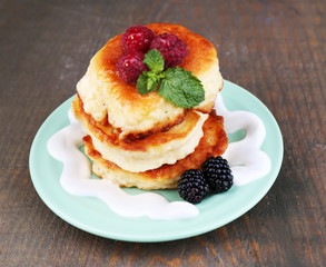 Tasty pancakes with fresh berries, cream and mint leaf