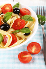 Obraz na płótnie Canvas Spaghetti with tomatoes, olives and basil leaves
