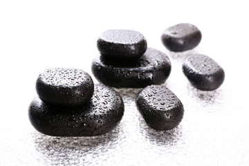 Spa stones with drops on light background