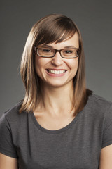 Fototapeta premium Braunhaarige Frau vor grauem Hintergrund, lachend, Portrait.