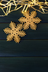 Garland and snowflakes on dark wooden background