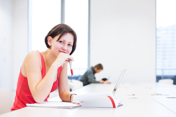 Obraz premium Pretty, young college student studying in the library