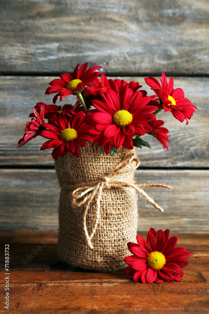 Sticker Beautiful chrysanthemum in vase on wooden background