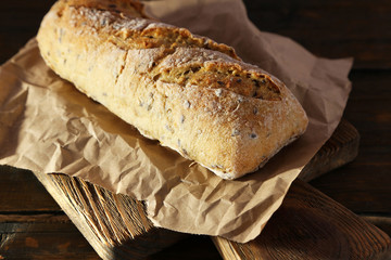 White bread on craft paper on cutting board on wooden