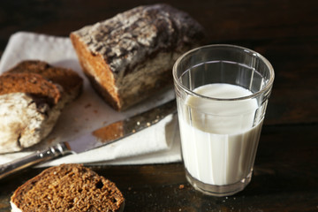 Fototapeta na wymiar Sliced rye bread, glass of fresh milk and knife