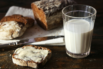 Sliced rye bread, glass of fresh milk and knife