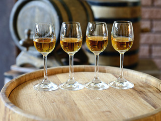 Glasses of wine in cellar with old barrels