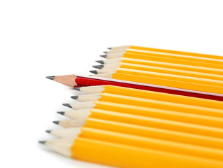 One red pencil standing out from others, isolated on white