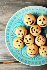 Tasty Halloween macaroons on plate, on wooden table