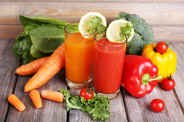 Carrot and tomato juice in glasses and fresh vegetables