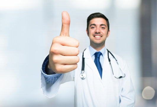 Friendly doctor smiling giving thumbs up