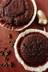 Two chocolate muffins on a red board