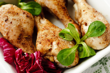 Roasted chicken legs in a white dish with herbs