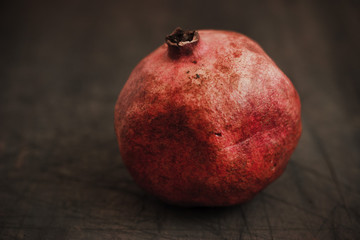 Red pomegranate on a grey table