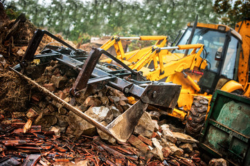 Fototapeta premium excavator loading demolition debris and concrete wasted walls