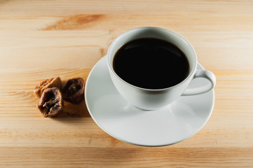 white cup of coffee on a wooden background and figs