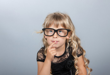 little girl in glasses thinking