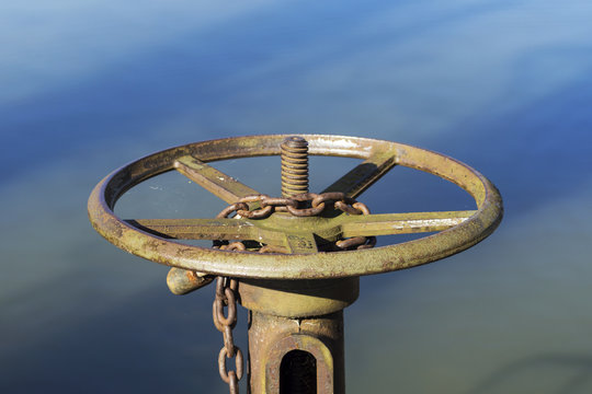rusty wheel by the pond