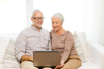 happy senior couple with laptop at home