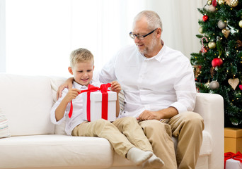 Obraz na płótnie Canvas smiling grandfather and grandson with gift box