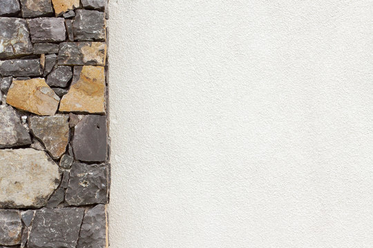 pilier de pierres naturelles et mur blanc crépi