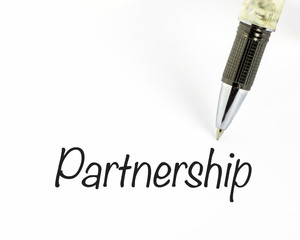 Pen writes partnership word on paper