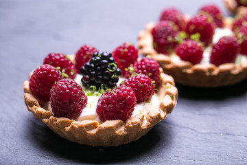 Delicious raspberry tarts on a stones board 