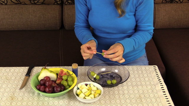 hand string grape pear fruit on  stick and put pan on table