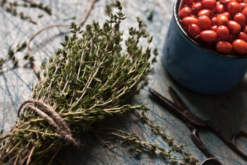 Naklejka premium Thyme bunch with a cord and a cup with sea-buckthorn