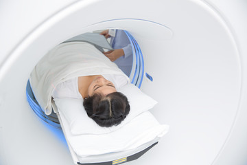 Asian lady sleep on a CT Scan bed