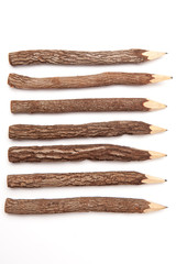 Wooden pencils made from tree branches isolated on white background