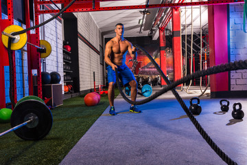 battling ropes man at gym workout exercise