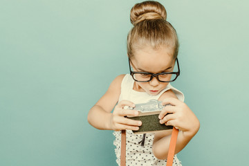 child holding a instant camera
