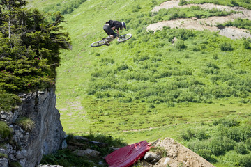 Mountainbiker jumping from a rock