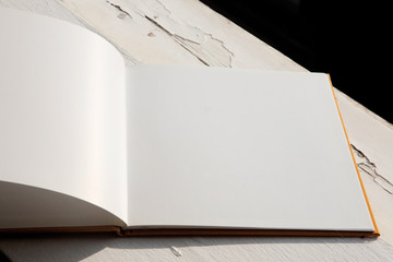 Open blank brochure on old wooden white windowsill. 