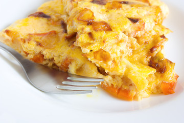 scrambled eggs with carrots and onions on a white plate