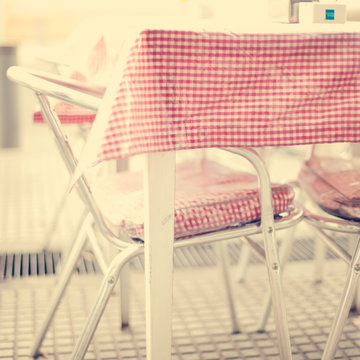Outdoors table in a cafe with checkered vintage tablecloth