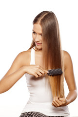 Obraz premium smiling beautiful girl combs her long hair